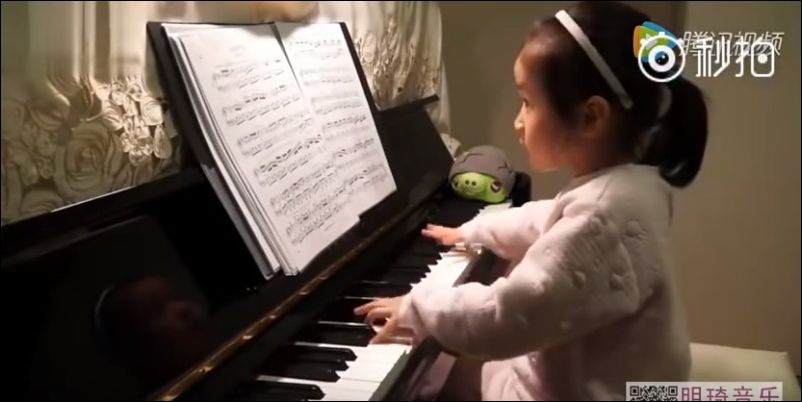 Маленькая девочка неплохо играет на пианино