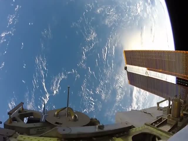 Работа космонавта в открытом космосе с видом на Землю