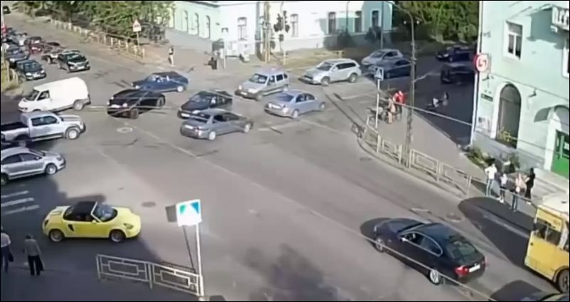 Девушка за рулем машины пытается преодолеть перекресток