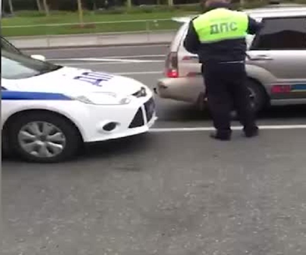 Сотрудники ДПС задерживают нарушителя, заблокировавшегося в машине
