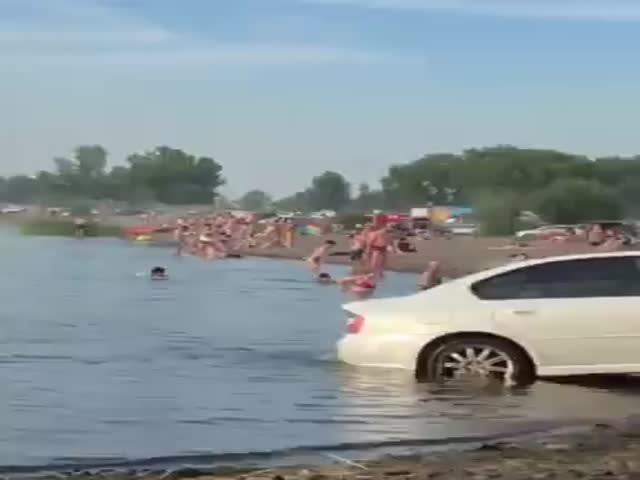 Мужчина решил помыть машину прямо возле купающихся людей