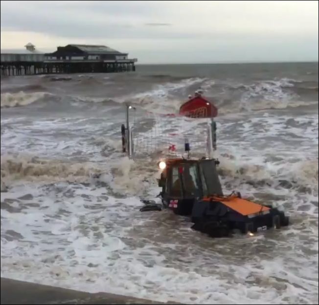 Трактор вытаскивает лодку со спасателями во время шторма