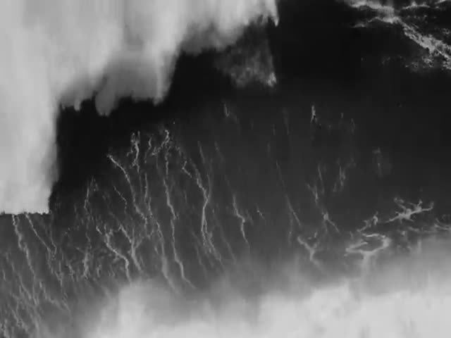 Серфер покоряет гигантскую волну в Португалии