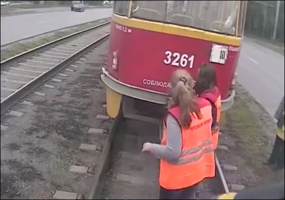 Женщины пытаются сцепить два трамвая