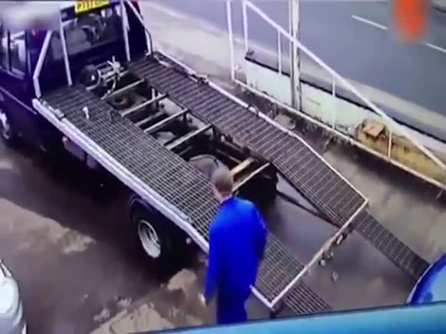 Эвакуаторщик пытается остановить скатывающийся с платформы автомобиль