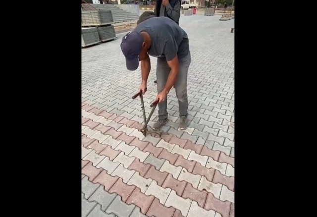Мужчина перекладывает тротуарную плитку после криворуких коллег