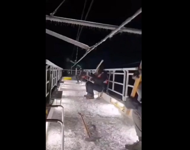 Необычное занятие - китайские рабочие сидят на крыше вагона и сбивают лед с проводов