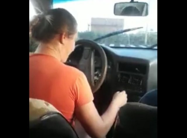 Девушка учится управлять автомобилем