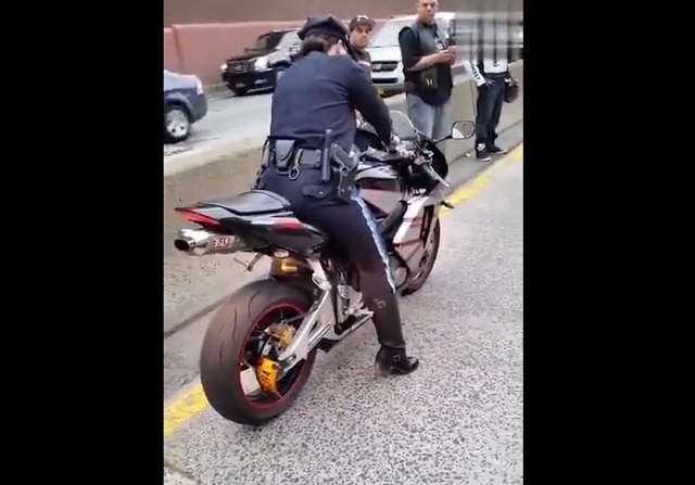 Женщина-полицейский пытается загрузить мотоцикл на эвакуатор