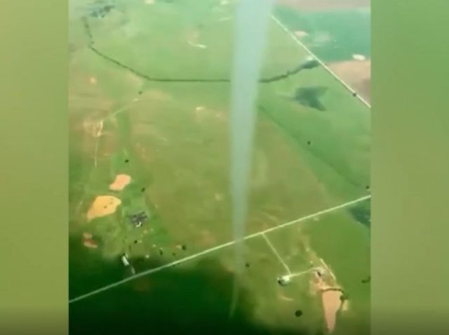 Пилот легкомоторного самолета летает возле торнадо
