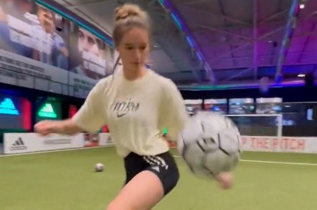 Симпатичная девушка неплохо управляется с футбольным мячом