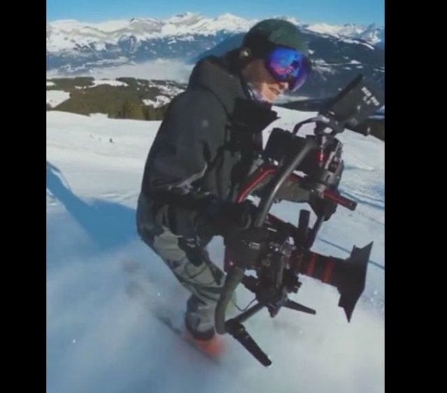 Талантливый оператор снимает спуск любителей горных лыж