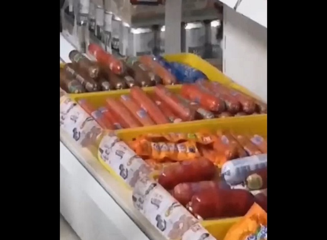 Проверяющий конфискует сосиску в магазине