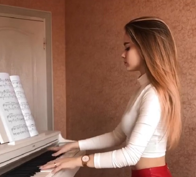Красивая девушка играет на фортепьяно